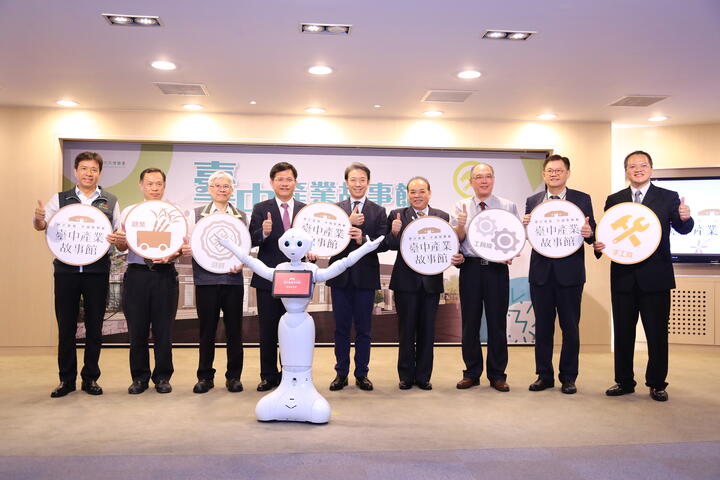 林市長與聖僑資訊公司總經理陳柏君等人大合照，以及機器人Pepper扮演「時空旅人」簡介台中產業故事館。