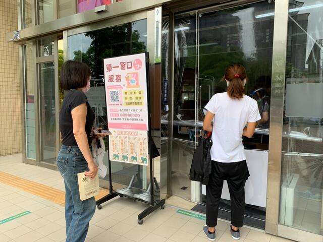 讀者依照分流時段前往圖書館-並保持安全社交距離排隊取書