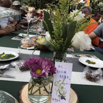 新社掛滿結實纍纍的紫色鮮果葡萄園裡-佐以溫和的秋季和風-邀請民眾在紫色浪漫的葡萄樹下品嘗美味佳餚