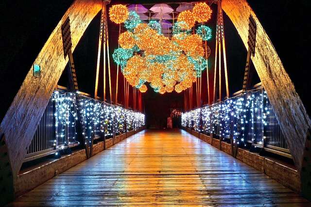 情人木橋園區的-光乍愛情橋-以紫色傘海搭配暖白藍色系的鐵骨球水滴